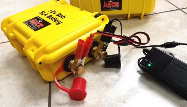 A yellow box with a 12v Geophysical Power Pack and charger next to it.