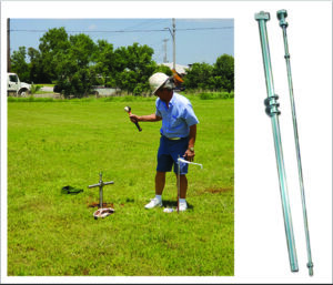 A man holding a BUFFALO SEISMIC PERCUSSION ROD in a field.