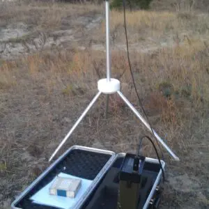 A Geometrics G-856 Magnetometer with a laptop on it sitting in a field.